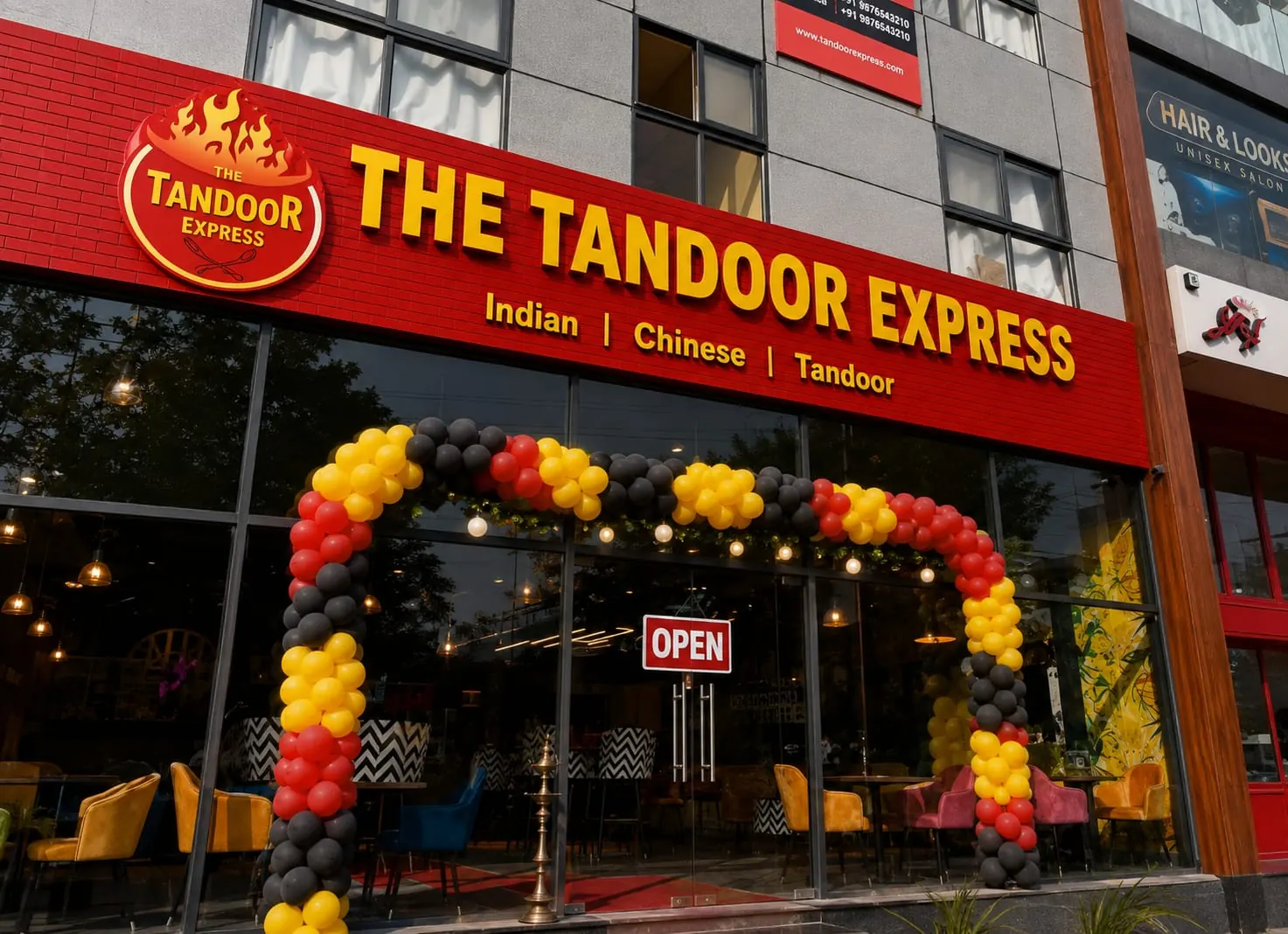 A THE TANDOOR EXPRESS opening with a red, yellow, and black balloon arch